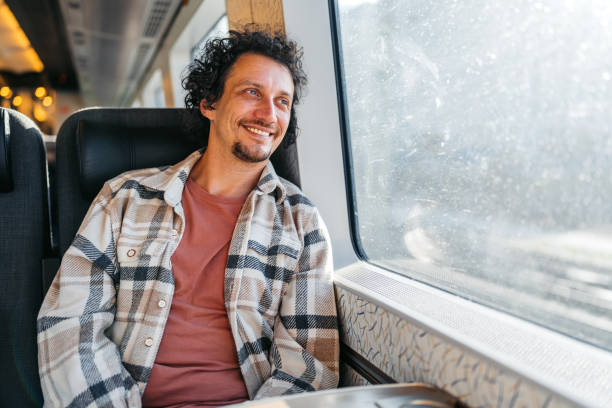istock Young Man Looking Out The Window On The Train 2047796960