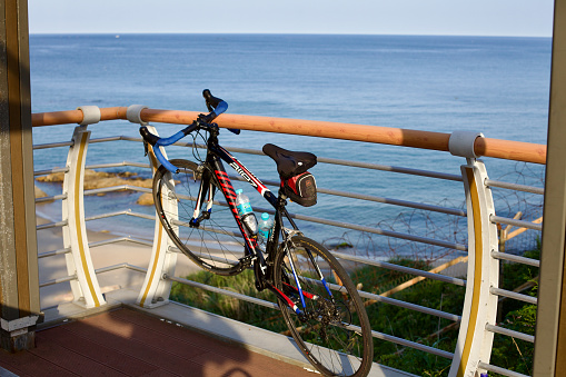 Yangyang County, South Korea - July 30th, 2019: A road bike hangs off the railing of a lookout platform, with the vast East Sea stretching to the horizon near Dongho Beach, invisible from this vantage point on a clear summer day.