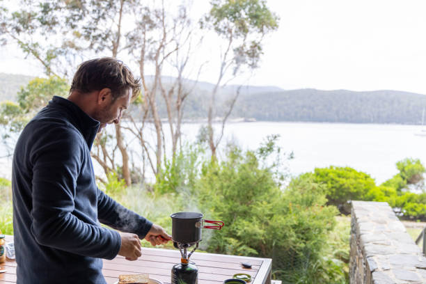 若い男がキャンプをして、自分で温かい飲み物を作る、ビーチの景色 - eucalyptus tree tree australia tropical rainforest ストックフォトと画像