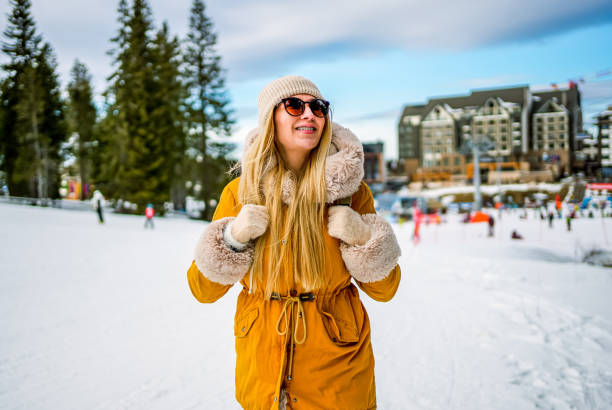 Young cheerful woman enjoying while walking in the snow covered mountain