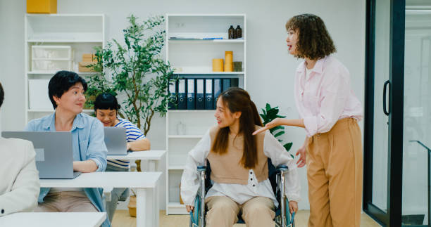 istock Dynamic office scene where a diverse team, including a new hire and a wheelchair user, engages in a lively discussion, showcasing a workplace that values inclusivity and sustainable practices. 2047829693