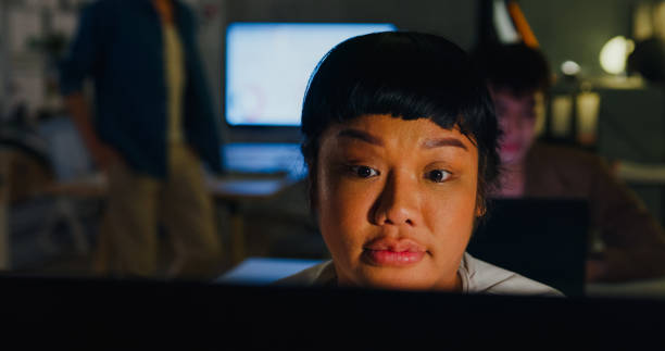 istock Asian plus-sized woman rests her head back, eyes closed, possibly sleeping at her workstation, highlighting issues of workplace exhaustion. ESG sustainable business office night. 2047830308