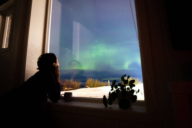 istock Young woman is watching northern lights. 2047837924