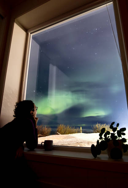istock Young woman is watching northern lights. 2047837942