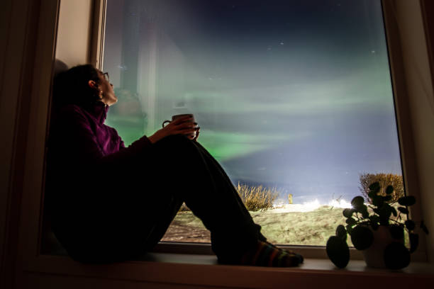 istock Young woman is watching northern lights. 2047838466