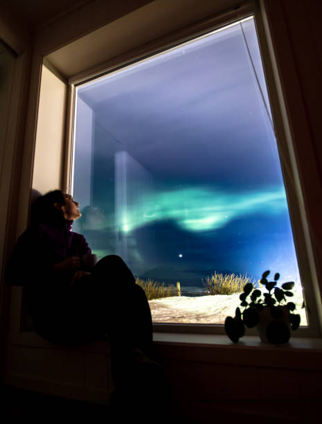 istock Young woman is watching northern lights. 2047838495