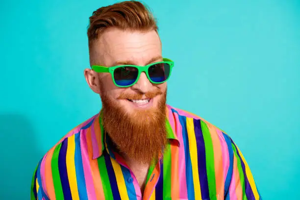 Portrait of handsome cheerful boyfriend in hipster shirt toothy smiling wear sunglasses rayban brand isolated on cyan color background.