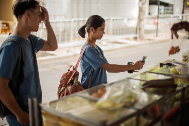 Man and woman healthcare workers in medical scrubs buying lunch at the street market.