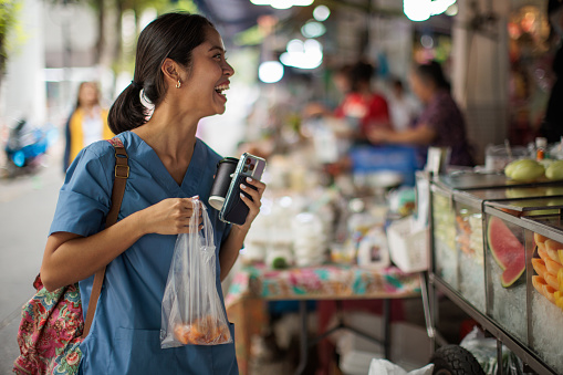 Woman healthcare worker buying lunch at the street market.