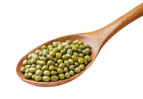 Mung bean in a wooden spoon close-up on a white background. Isolated