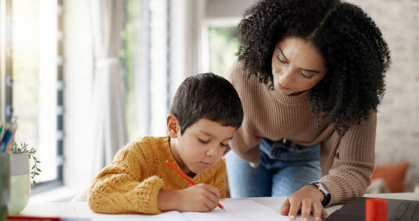 istock Homework, learning and help with mother and son for homeschooling, research and math. Education, study and teaching with woman and kid in family home for child development, writing and knowledge 2047855373
