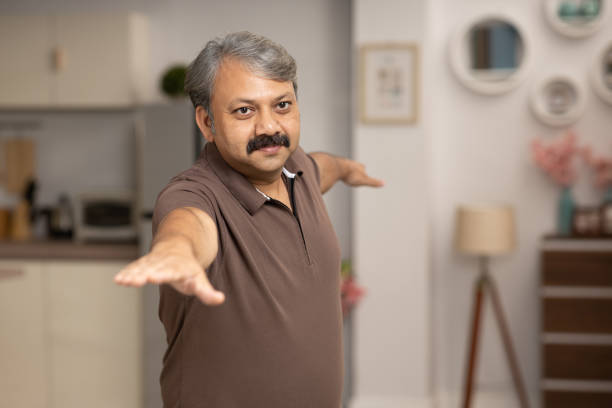 istock Mature man practicing yoga at home stock photo 2047855914