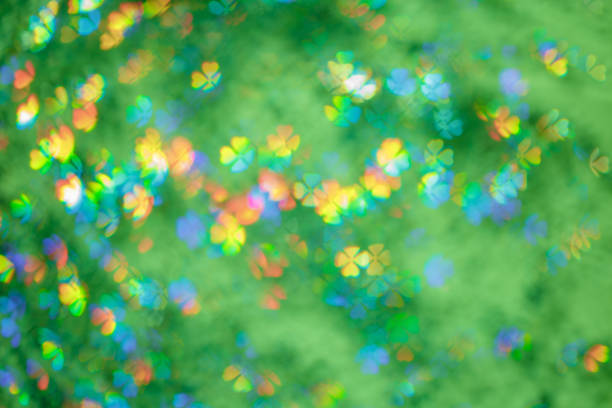 istock Defocused abstract botanical bokeh background green color, flare from lights, summer blurred bokeh of clover leaves shape as holiday texture. Bright aesthetic textured lighting pattern 2047864928