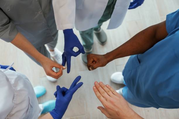 じゃんけんゲーム。信頼関係で手をつないでいる医師たち - rock paper scissors ストックフォトと画像
