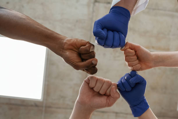 istock Group of doctors are holding hands in trust together 2047871715
