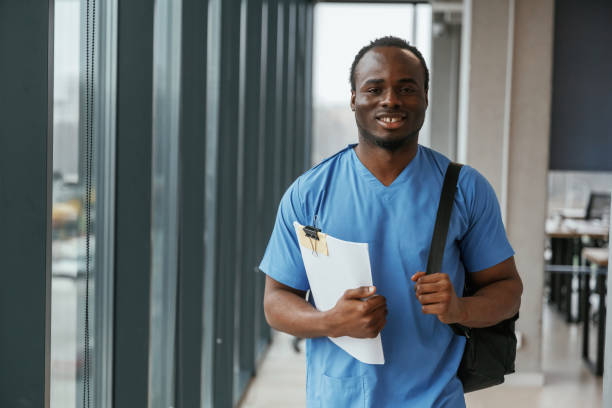 istock Black man doctor is standing indoors and holding documents in hands 2047876018