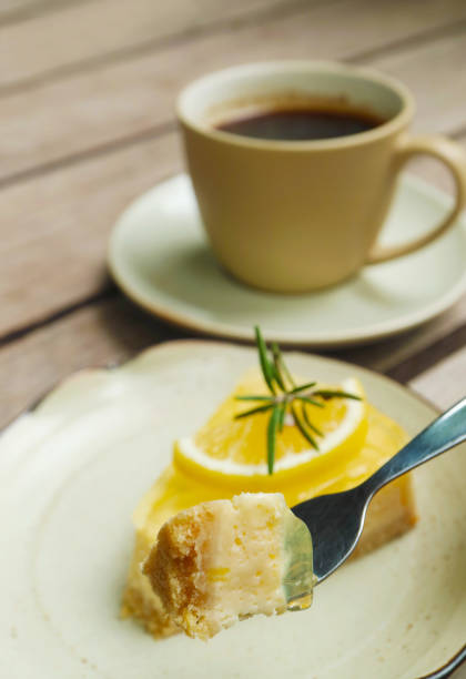 istock Fork scooping mouthwatering lemon cream cheese pie with blurry coffee cup in the backdrop 2047882164