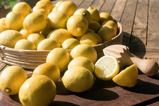 bunch of fresh lemons with manual wooden citrus press