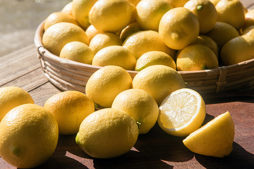 Fresh lemon fruits in a wooden box  on a wooden rustic table, top view