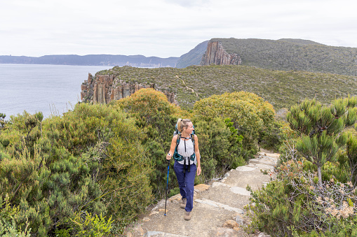 She embarks on a trekking adventure, long distance trail. She carries all her needs in the backpack. People travel outdoor activities concept