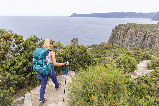 She embarks on a trekking adventure, long distance trail. She carries all her needs in the backpack. People travel outdoor activities concept