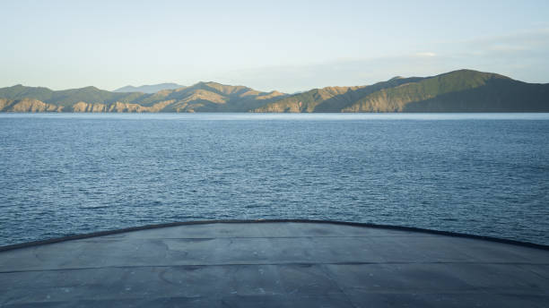blick auf den bug eines großen transportschiffs, das sich während der fahrt dem land nähert, neuseeland - marlborough region sunrise new zealand sea stock-fotos und bilder