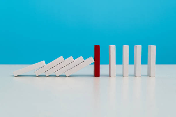 istock Red wooden block stop other falling dominos 2047948396