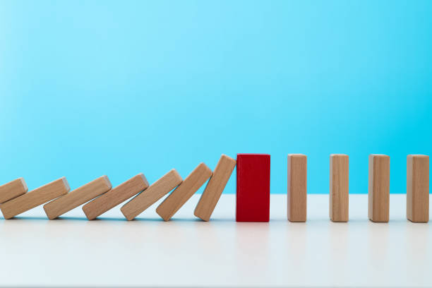 istock Red wooden block stop other falling dominos 2047949524