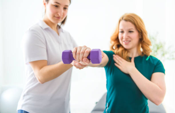 istock Modern rehabilitation physiotherapy at work with client holding dumbbell 2047970589