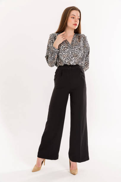 istock Brunette young woman wearing patterned blouse and black trausers. 2047979892