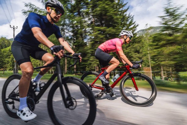 istock Active Couple on High-Speed Bikes Riding Bicycles Downhill 2047984708