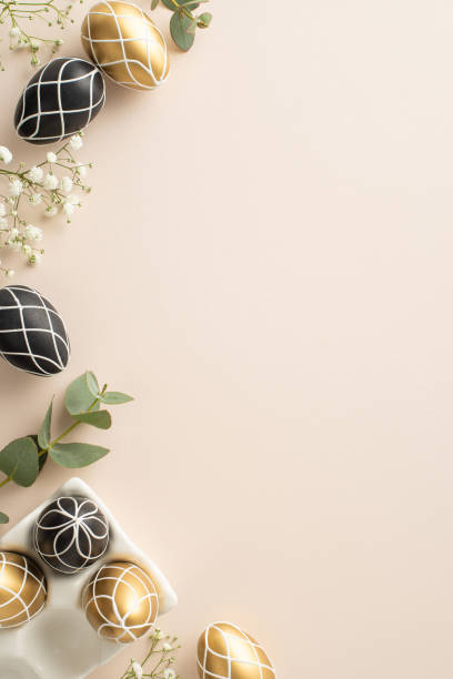 istock Elegant Easter setting: Overhead vertical image of rich black and gold eggs in a pottery stand, eucalyptus foliage, gypsophila, placed on a light beige backdrop, space for wording 2047995730