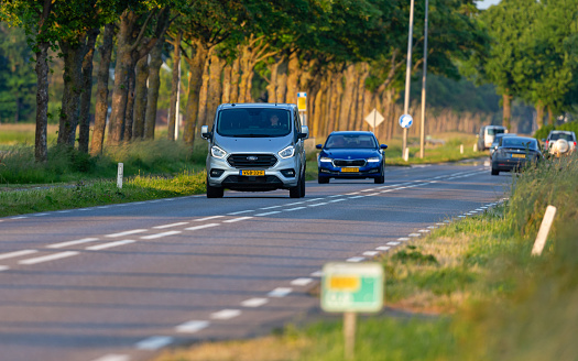 Netherlands, South Holland,  Alphen aan den Rijn, Benthuizen, June 7th 2023, Dutch gray 2020 Ford 1st generation 'Transit Custom' van and other traffic  driving on the N209 road at Benthuizen in the direction of Zoetermeer just before sunset, the Transit Custom van is made by 'Ford of Europe' since 2012, the N209 is a 26 kilometer long road in South Holland