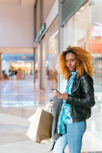 istock Black woman texting from a shopping mall 2048022617