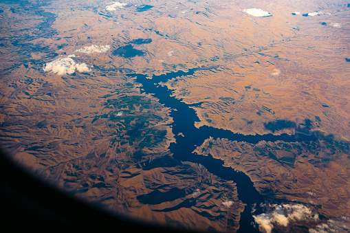 View from the airplane window mid air, above Kazami Dam lake in Iran.