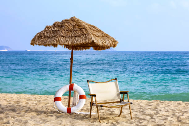 A white wooden lifeguard chair facing the clear turquoise waters and soft sandy beach at Kenting, Taiwan, under bright sunlight