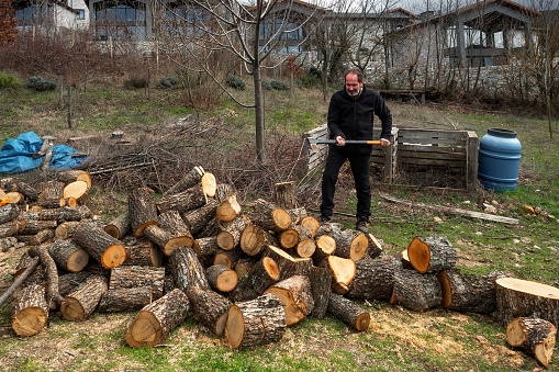 Simple Village Life: Man in Garden Splitting Logs with Axe