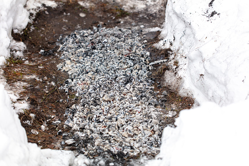 Fire with coals on the snow in winter.