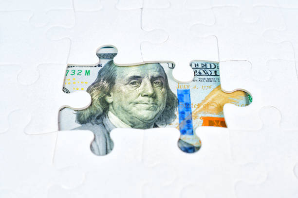 istock US Dollar Bill and Jigsaw Puzzle Background 2048104990