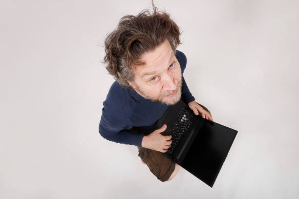 man working on his laptop looking at camera clear background