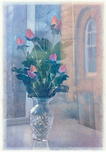 A tall, crystal, glass vase filled with unopened red roses and green stems and leaves, set on a shiny surface with a stone building and window in the background.