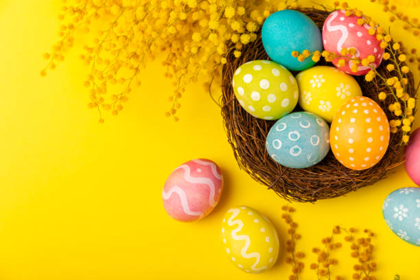 istock Easter basket filled with colorful eggs and a bouquet of tulips on  table. Easter celebration concept. Colorful easter handmade decorated Easter eggs. Place for text. Copy space 2048122127