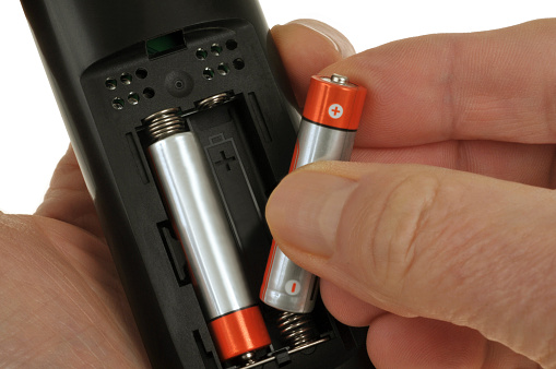 Putting batteries into a remote control close-up