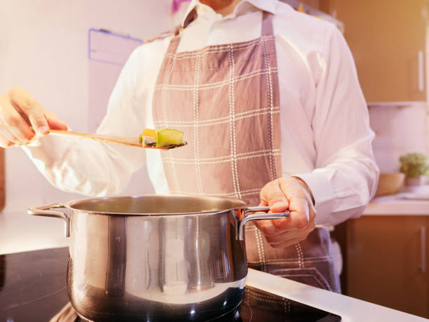 istock Chef in apron cooking vegetables in a pot 2048136953
