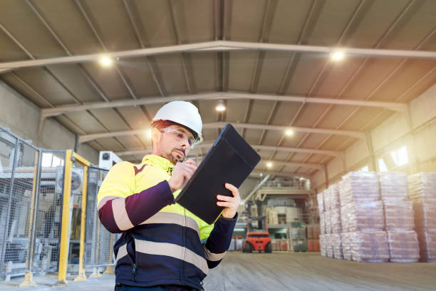 An engineer man making notes on his clipboard in a factory. Concept of Industry