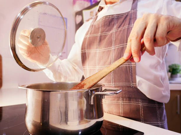 istock A chef stirs a pot on the stove. 2048137982