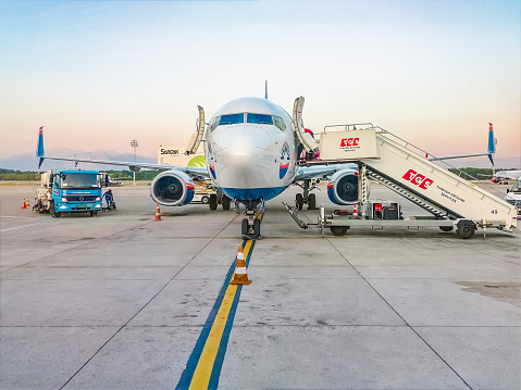 Antalya, Turkey - October 28, 2019: Front view of an airplane being prepared for takeoff at Antalya Airport. Plane and service equipment and transport on the runway