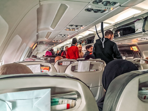 Antalya, Turkey - October 28, 2019: Passengers and flight attendants on board the airplane. Boarding a plane - view from the passenger seat
