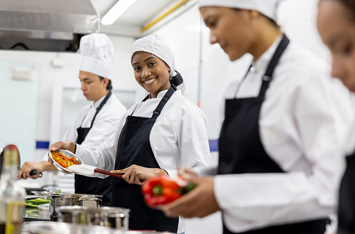 Happy African American woman smiling in a cooking class and looking at the camera - education concepts