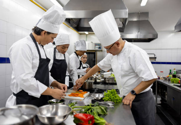 istock Chef teaching students how to chop vegetables in a cooking class 2048177040